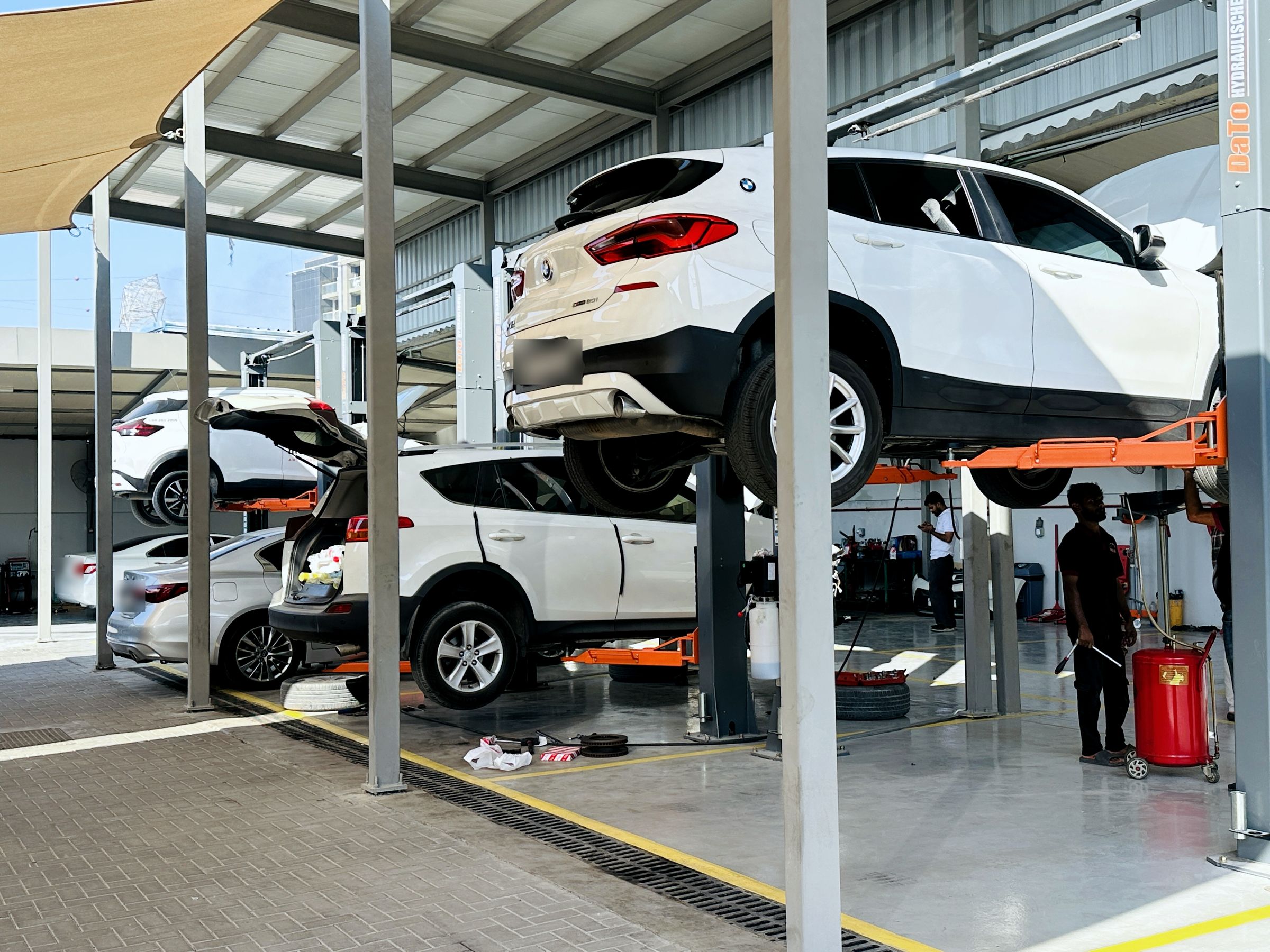 Row of two-post hydraulic lifts with vehicles raised for service