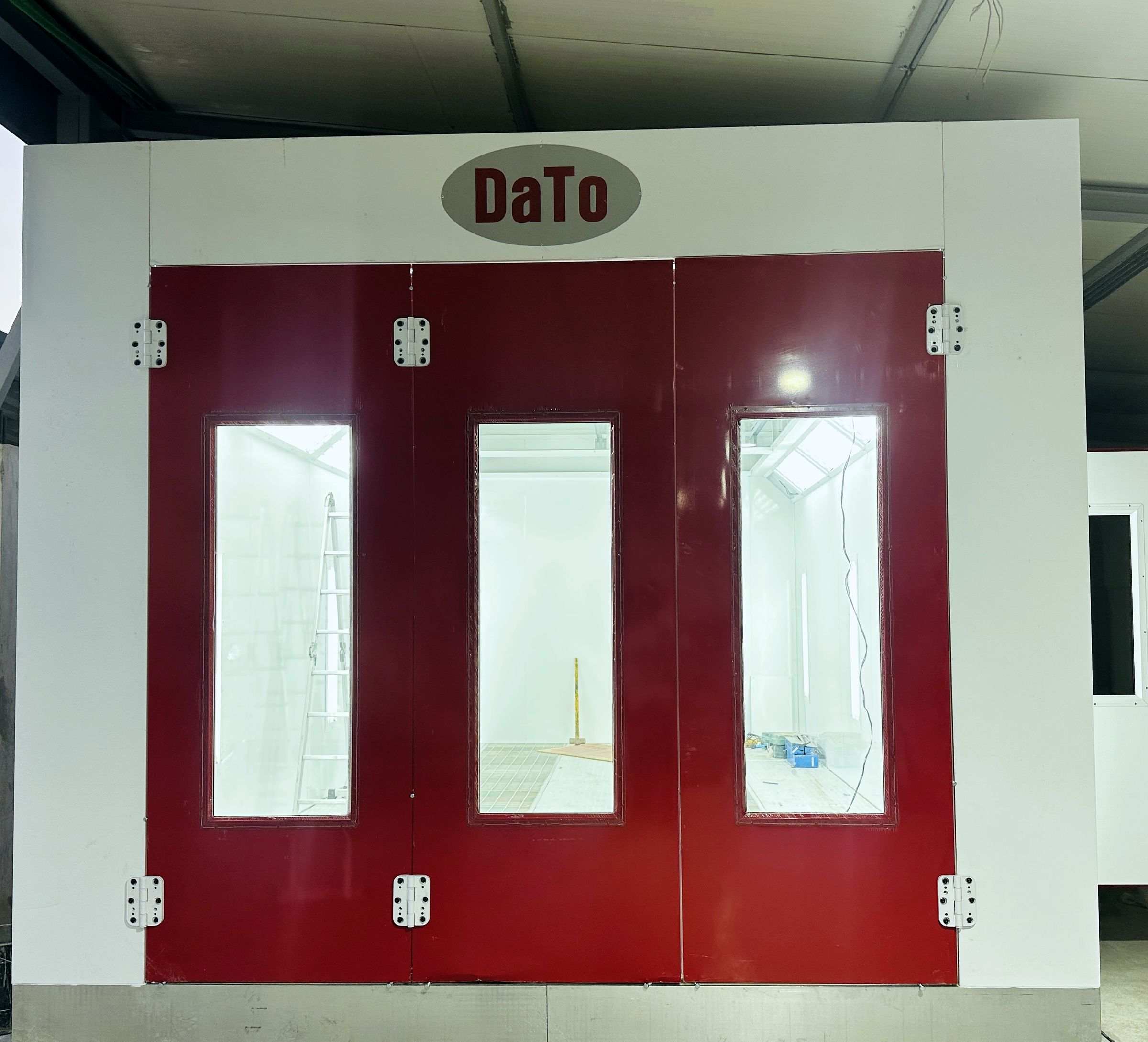 Red DaTo spray paint booth with lit interior at Drive Way Classic Garage